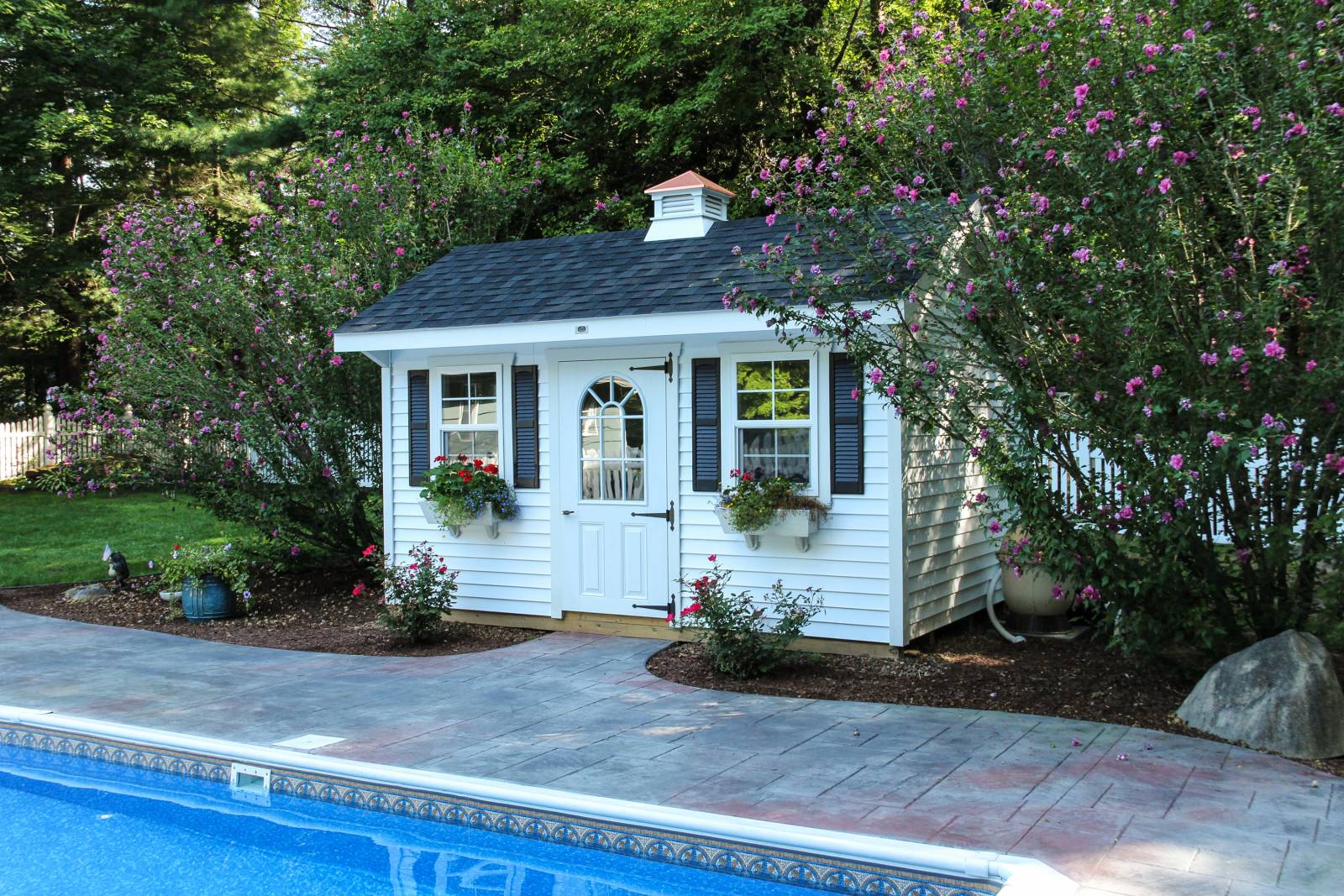 Landscaped beautifully with paver walkway up to pool house