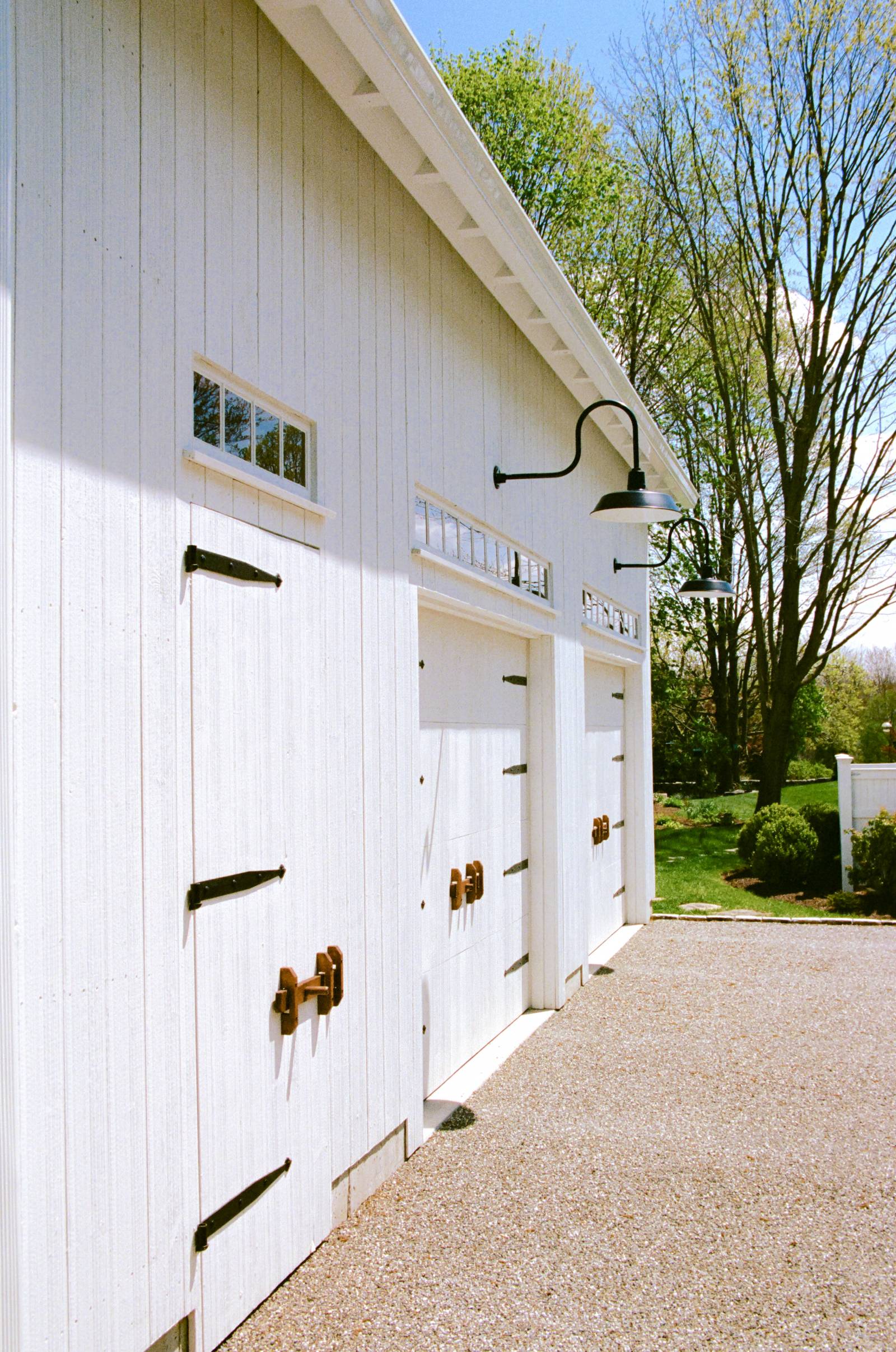 Gorgeous details on this barn: oak latches • authentic strap hinges • vertical pine • pine faced overhead doors • gooseneck lighting •Â transom windows