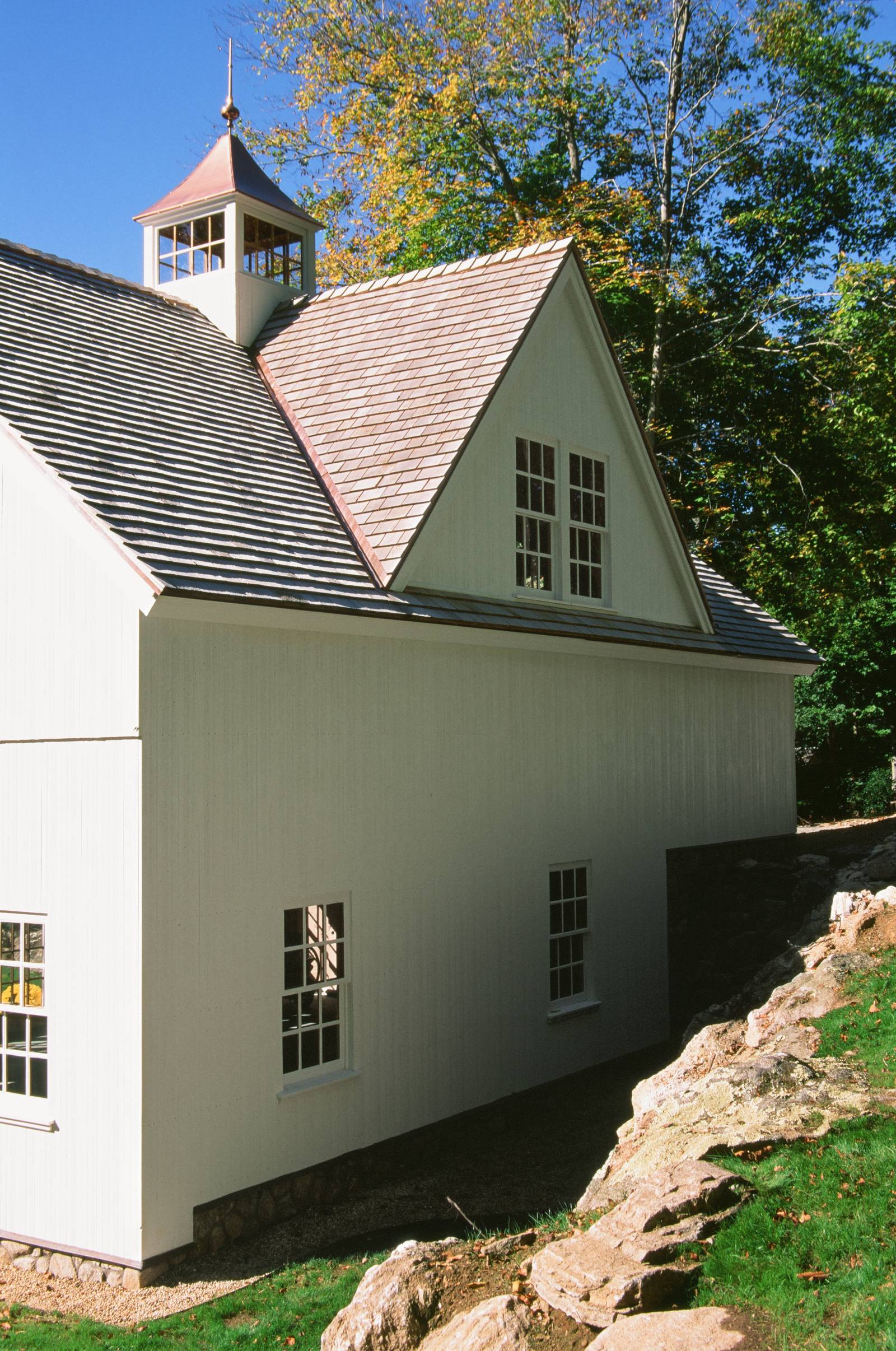 Cupola with finial • reverse gable dormer with windows • stone capped foundation detail of this bank barn
