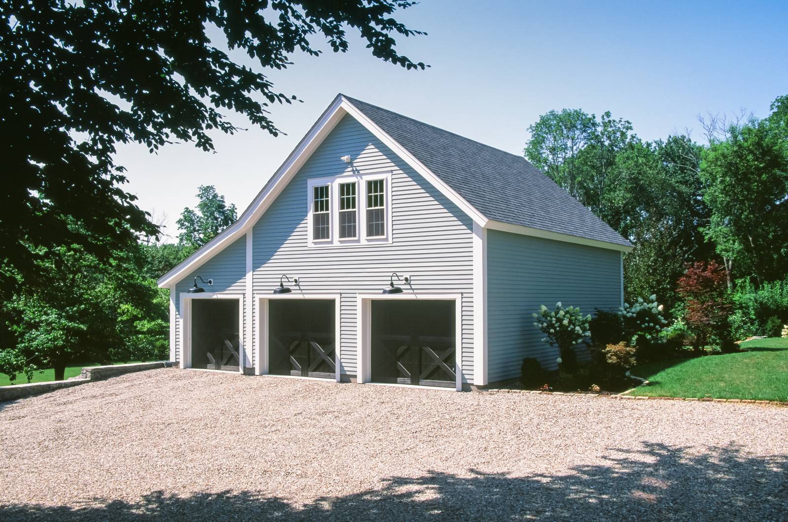 Carriage Barn with Hemlock Clapboard Siding • Wide PVC Trim • 12in. Overhangs • Crossbucks in the 3 Overhead Doors
