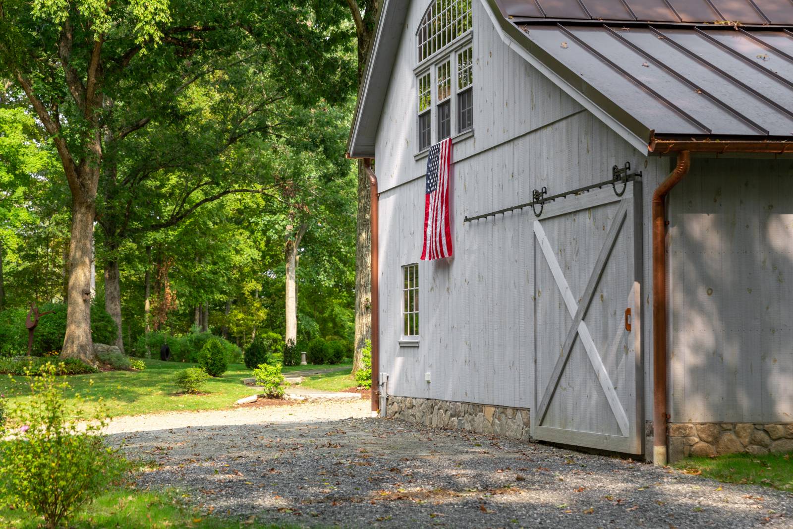Metal Roof • Sliding Barn Door • Stone Facade on Foundation