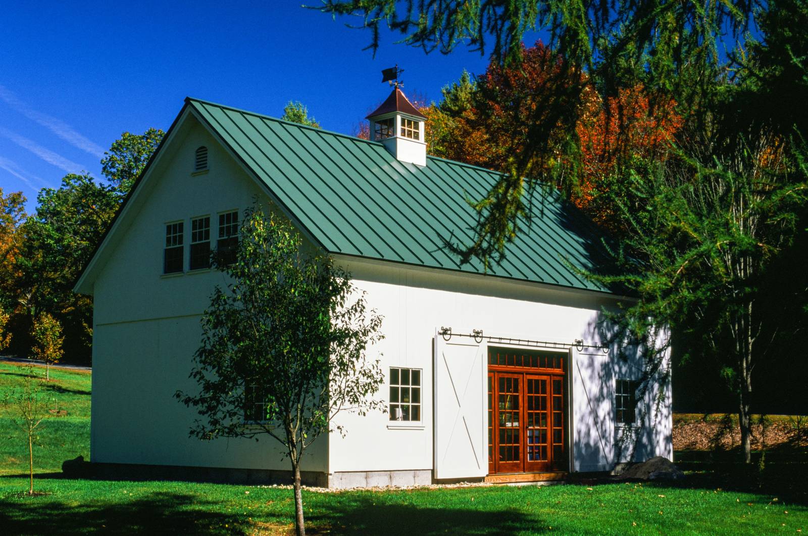 Pine split sliding doors open to reveal the entry to this Vermont barn