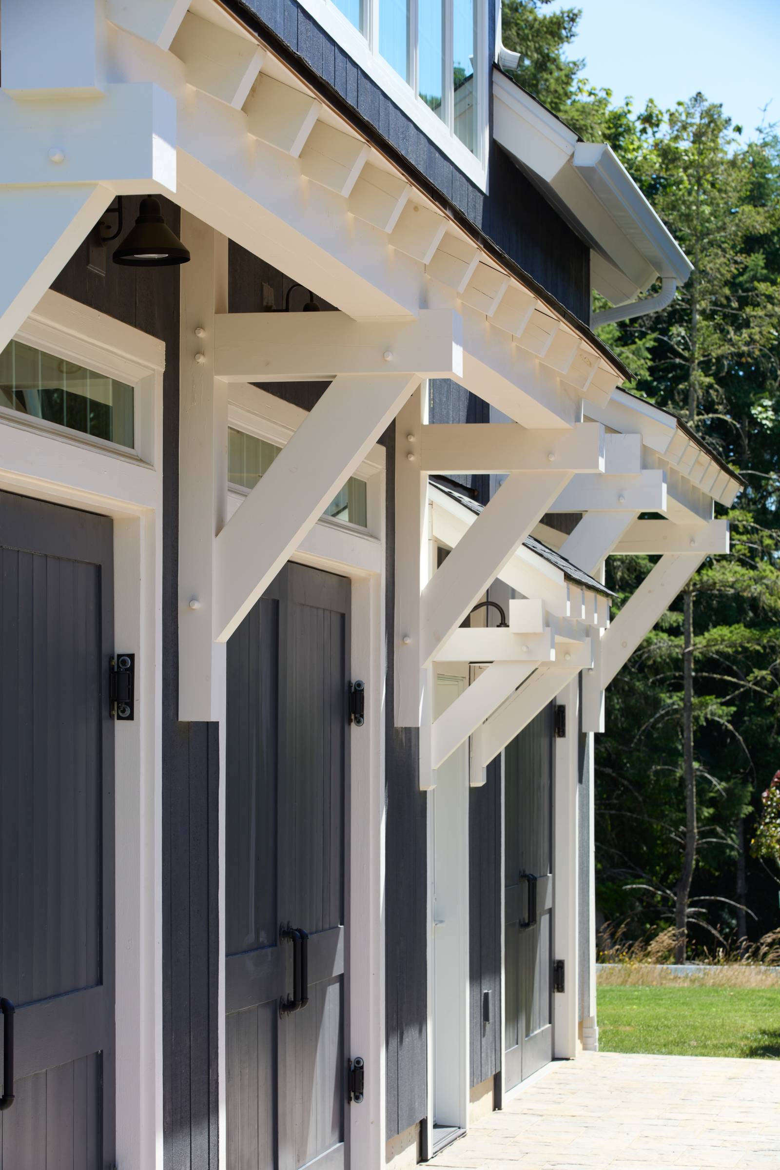 Timber frame eyebrow roofs above overhead doors