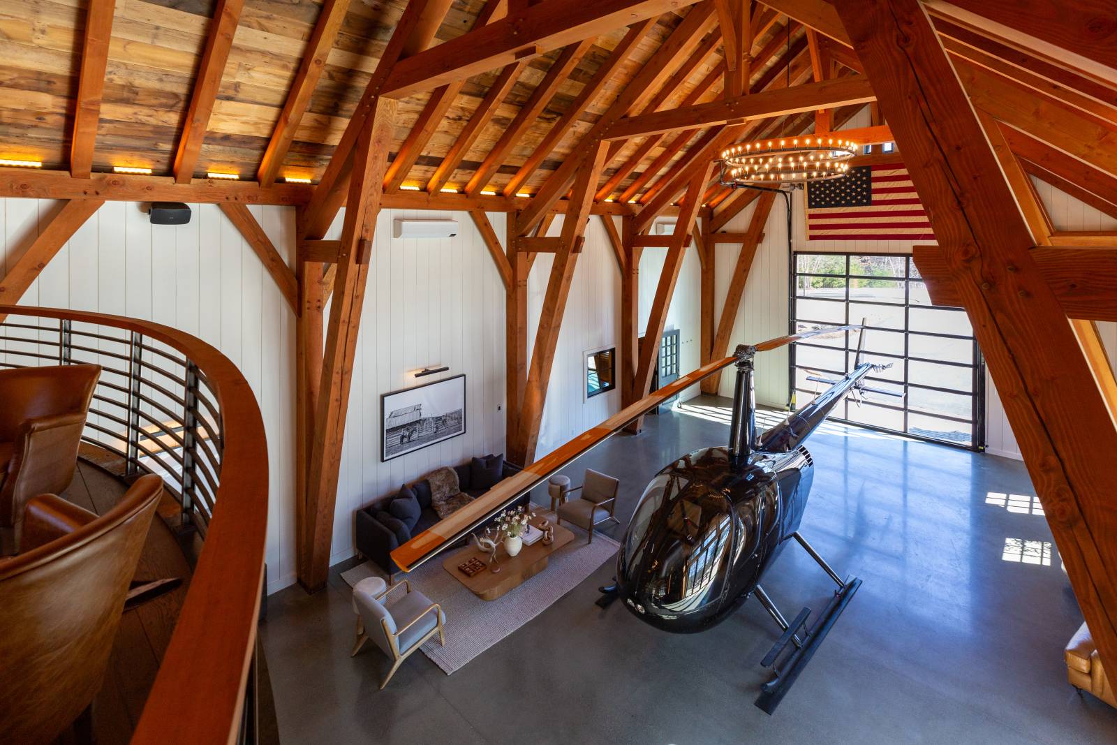 The view from the loft showing the helicopter and seating area • Custom timber frame barn