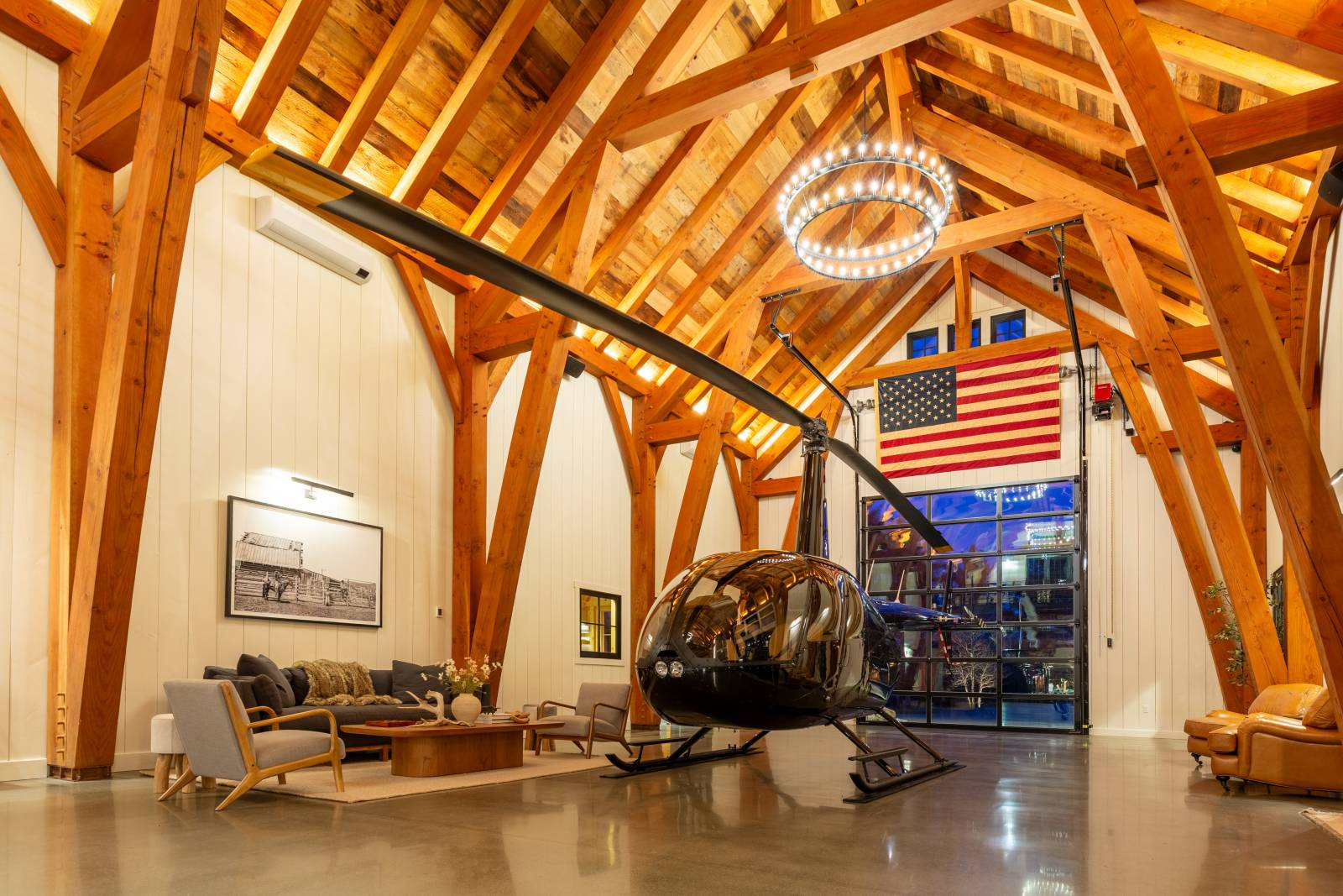 The timber frame barn has a sling brace design, creating a tall space with cathedral ceilings ideal for this Robinson R44 helicopter