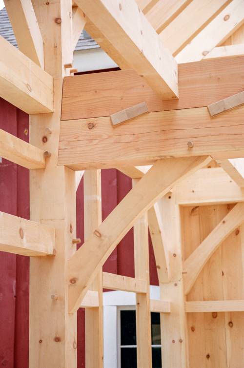 Detail: housed key beam with existing barn in background