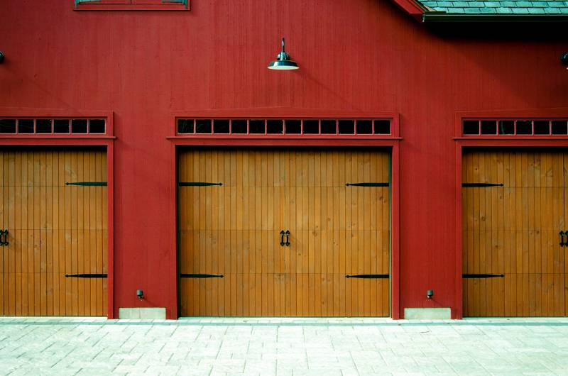 3 pine faced overhead doors with strap hinges & transom windows above