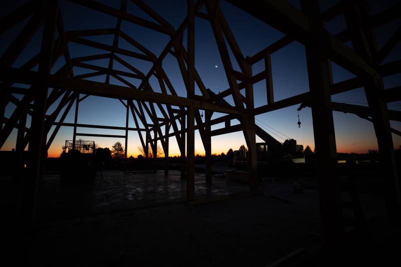 Early pre-dawn light silhouettes the timber frame • Sliver of the moon