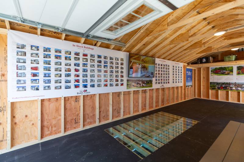 Inside the 14' x 30' Classic Cape Garage with Poly Armor Floor System, Super Floor cutout display, and Stock Board