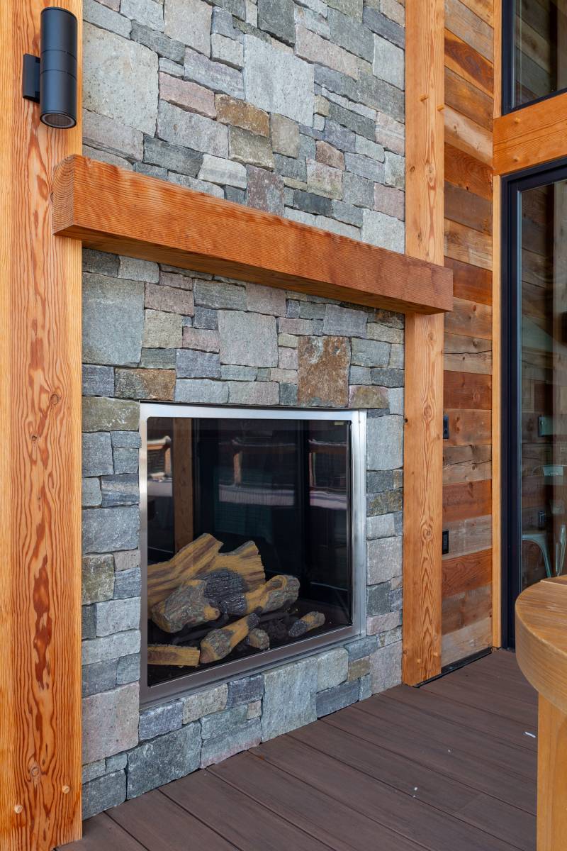 Natural Fieldstone Fireplace on Covered Porch of Mountain Modern Home