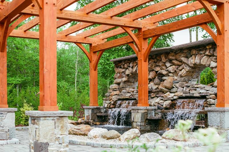 A Stone Structure with Waterfalls on One End of the Pergola