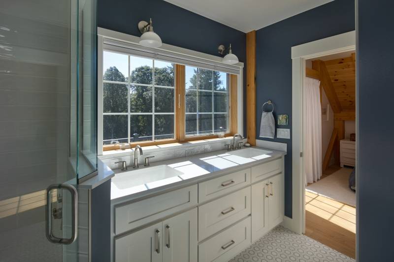 A full bathroom off of the primary bedroom • barn home living post & beam