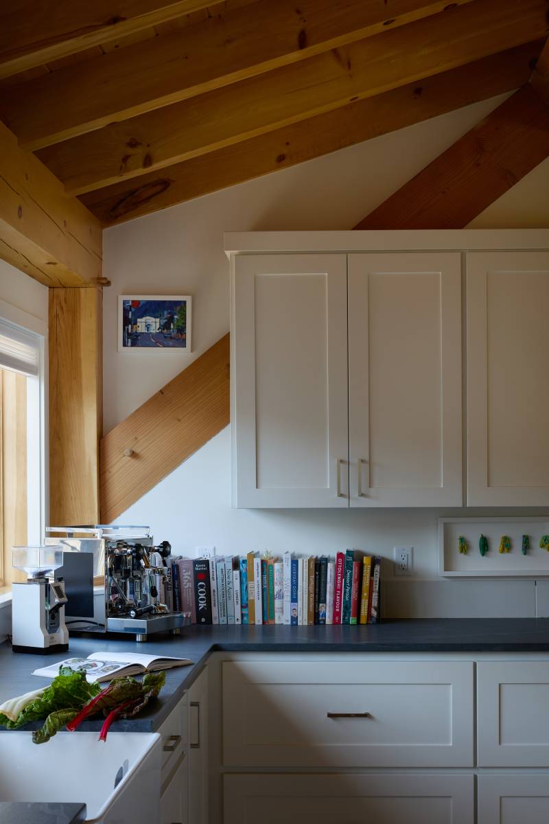 The shed dormer creates more usable vertical space in the kitchen • timber frame house