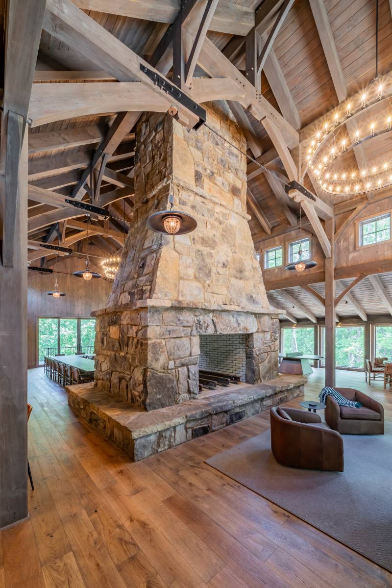 A massive fireplace at the center of this post & beam barn’s interior