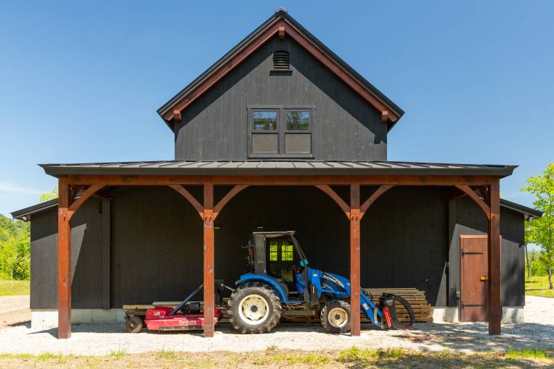 The timber frame lean-to has a 10' clearance to fit a tractor • post & beam barn