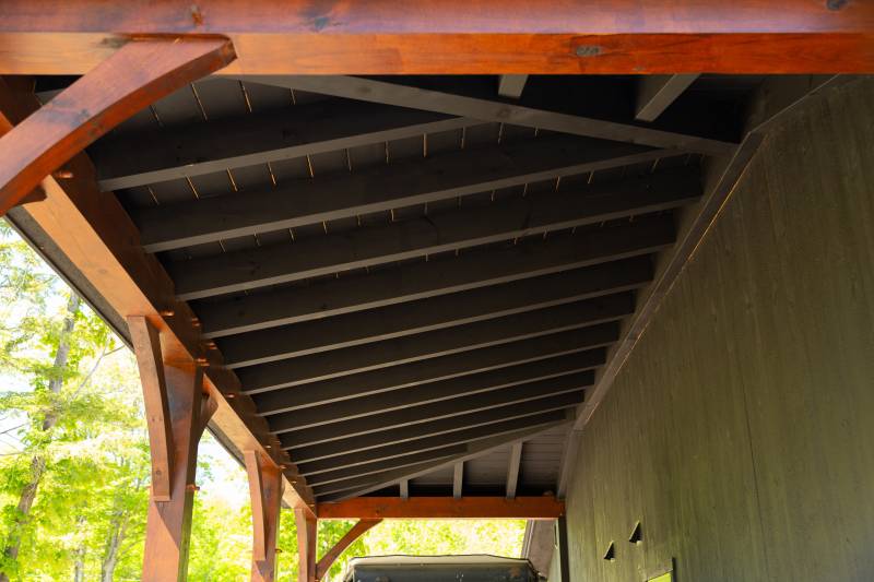 Underneath the hip roof lean-to • Rafters stained to match the siding
