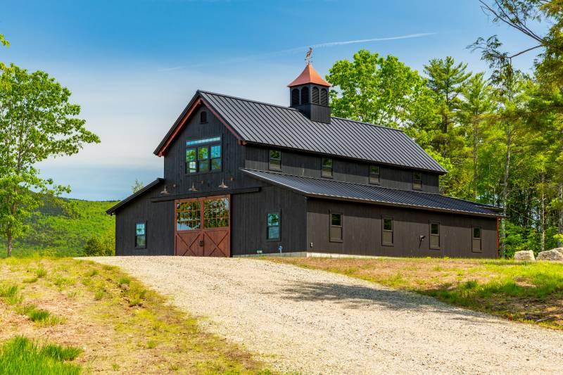 A dirt road leads to the post & beam barn’s front door