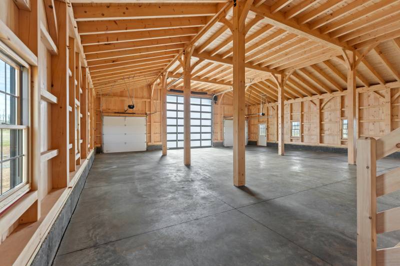 Three overhead doors lead into the timber frame barn