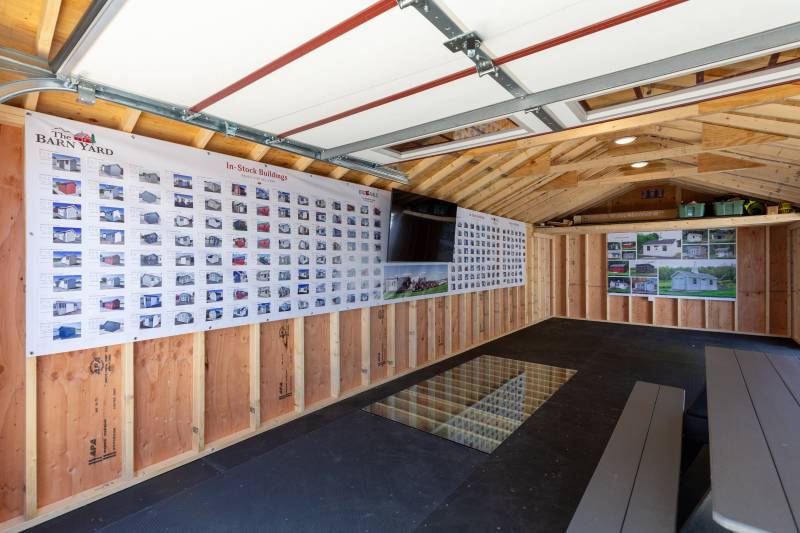 Inside the 14' x 30' Classic Cape Garage with Poly Armor Floor System, Super Floor cutout display, and Stock Board