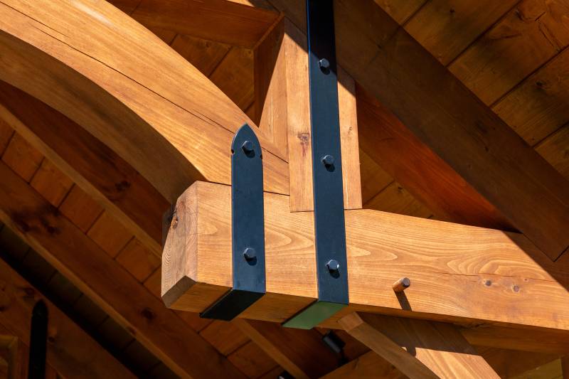 A closeup of the powder coated steel strapping in the trusses • timber frame pavilion