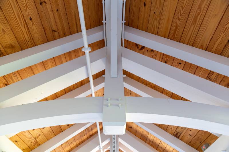 Looking up at the trusses • White timbers & stained roof decking