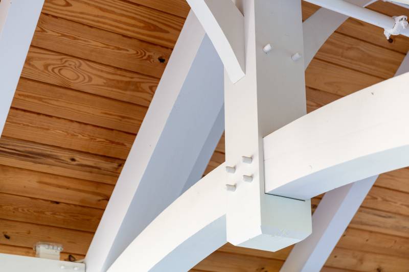A closeup of the white-painted king post trusses