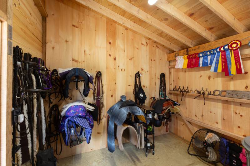 Saddles, halters, reins, and more within the barn’s tack room