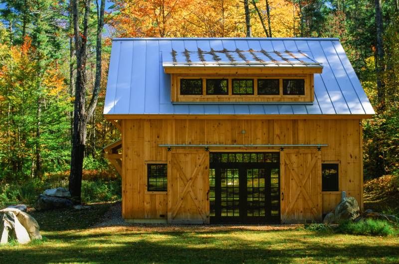 Sliding barn doors open to reveal full glass double doors with sidelights & transom