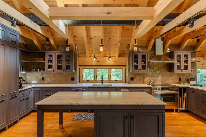 The kitchen, complete with dark cabinets, stainless appliances, and Andersen awning windows