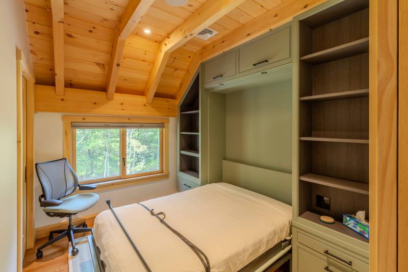 A bedroom with Murphy bed within the timber frame barn’s loft