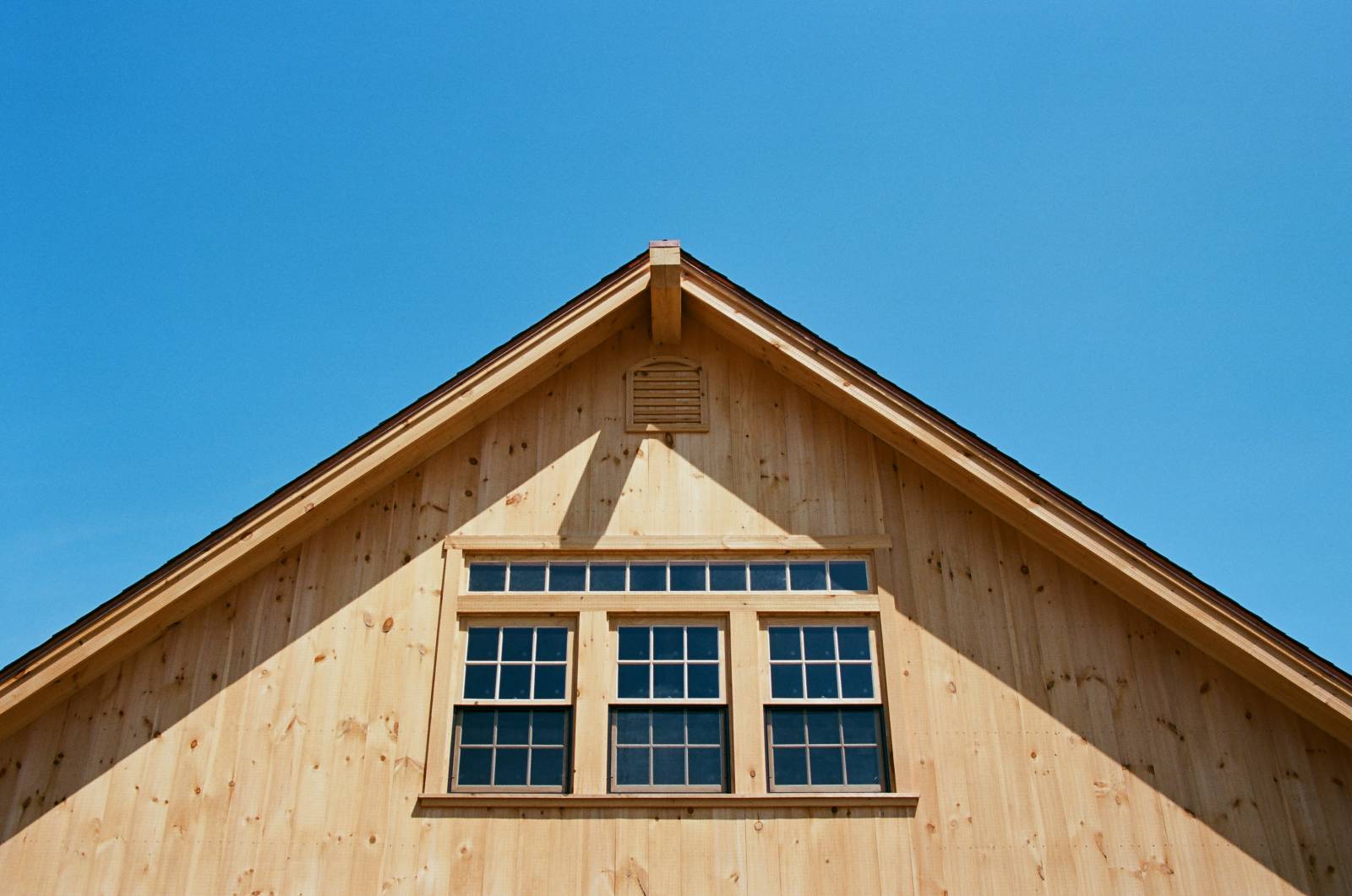 Three pine windows banked together with transom window above