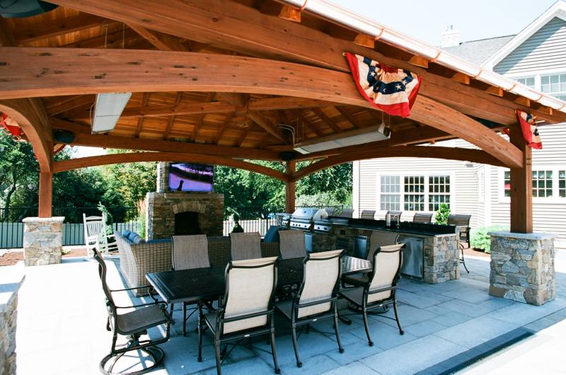 A place for everything: dining area • seating area by fireplace & TV • outdoor kitchen with bar