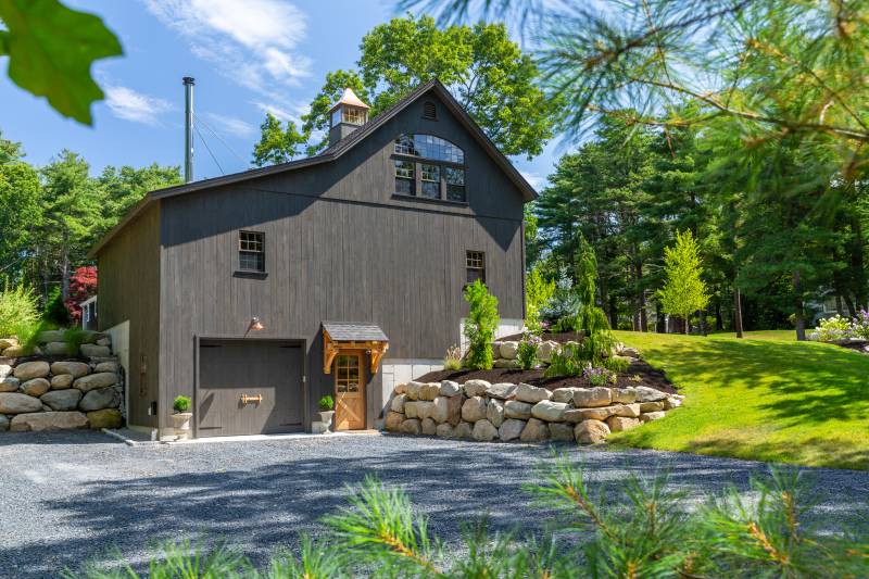 3-story bank barn with lower level garage door access • Timber frame eyebrow roof