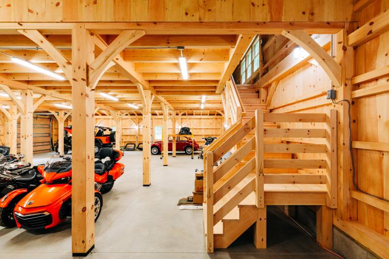 Timber stairs lead up to the post & beam barn’s second floor loft