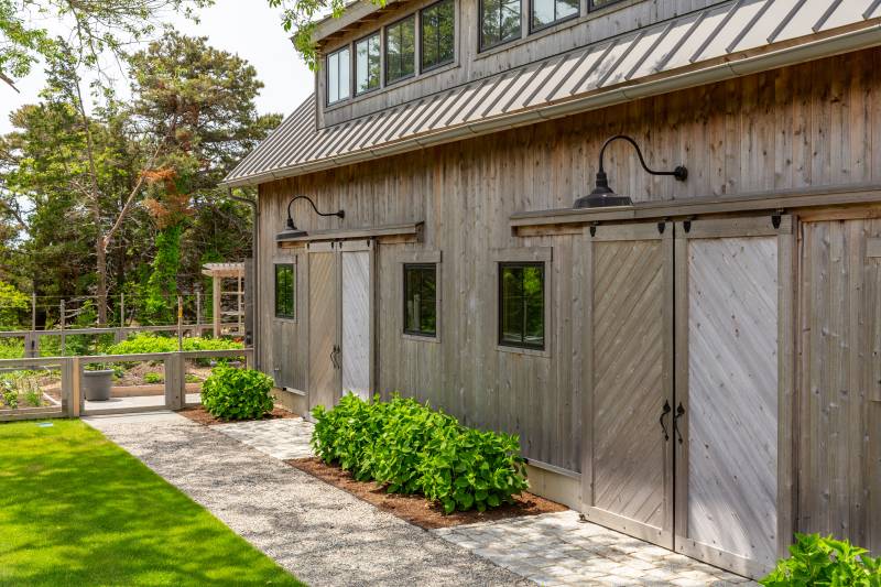 A stone walkway leads to the barn and the garden beyond