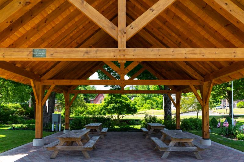 Four picnic tables beneath the timber frame pavilion